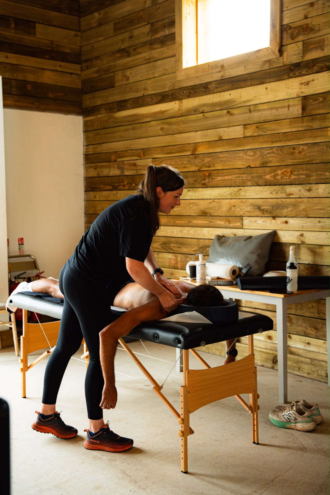 Sports massage therapist working on a client's upper back in the treatment room